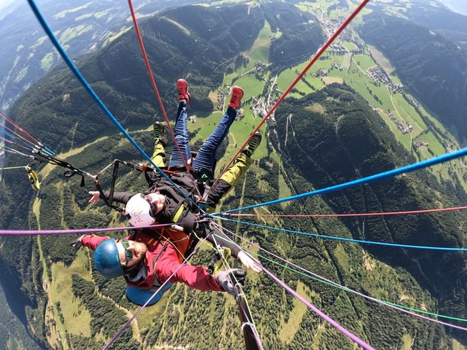 Porträt älterer Freunde, die mit erhobenen Armen auf einer Gruppenreise eine touristische Sehenswürdigkeit besuchen 